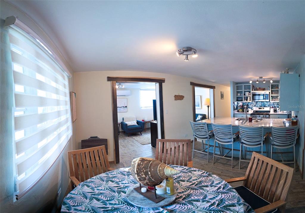 A dining area with a round table opens into a kitchen with a breakfast bar — Coco Beach S 110 GAVIOTA UNIT 110, RIO GRANDE, PR