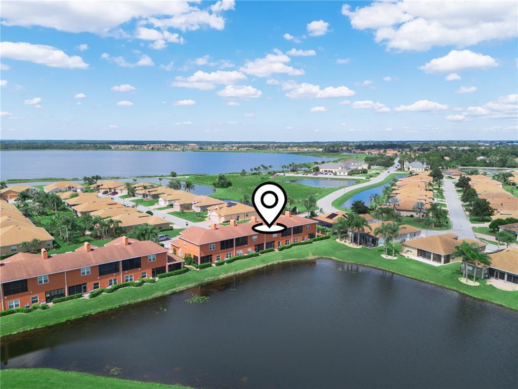 An aerial view shows a multi-unit residential building situated along a lake in a neighborhood — 1102 ASHTON PALMS DRIVE, LAKE WALES, FL