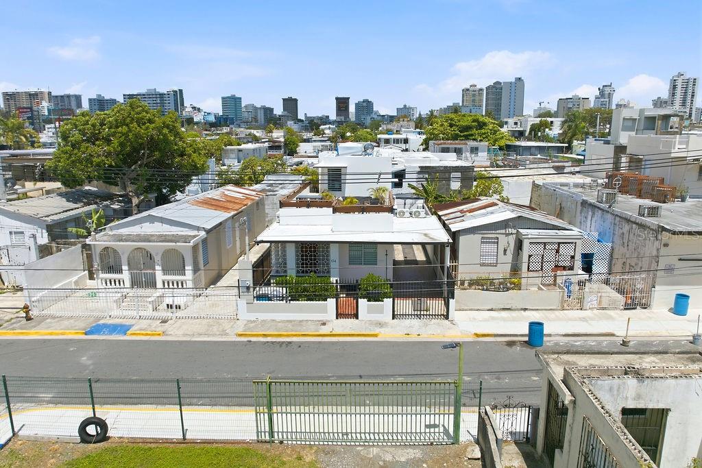 An elevated exterior view of a residential street featuring three small houses with flat roofs — 134 MARIA MOCZO, SAN JUAN, PR