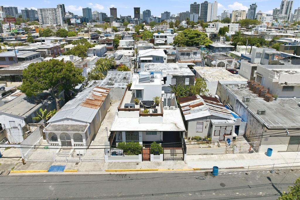 An aerial view shows a white house with a rooftop terrace between two smaller buildings — 134 MARIA MOCZO, SAN JUAN, PR