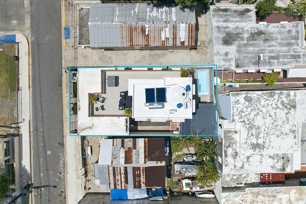 An aerial view shows a flat-roofed building with a rooftop terrace, pool, and solar panels — 134 MARIA MOCZO, SAN JUAN, PR