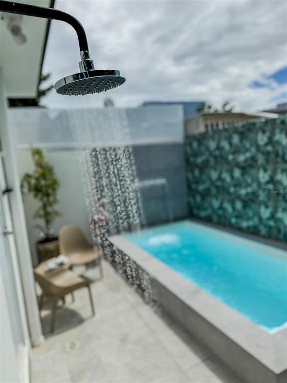 An outdoor shower head sprays water over a small rectangular swimming pool on a patio — 134 MARIA MOCZO, SAN JUAN, PR