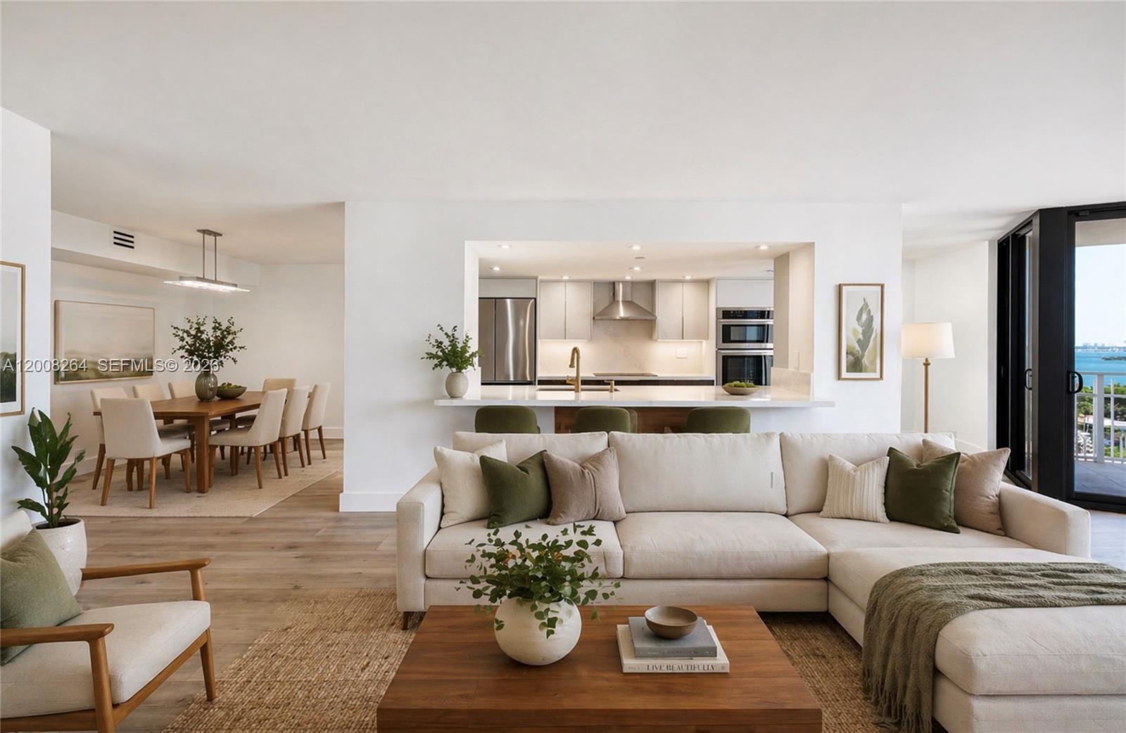 A bright open-concept living room and dining area with a kitchen pass-through and balcony view — 2000 Towerside Ter # 1506, Miami FL 33138, MIAMI, FL