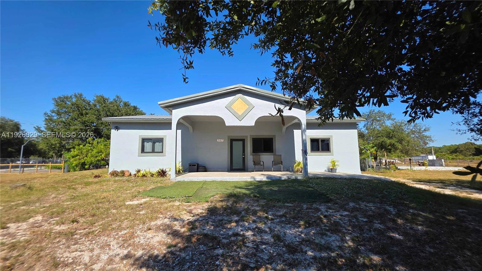 A single-story house with a covered front porch and a light gray exterior — 527 PERIMETER RD, Clewiston FL 33440, CLEWISTON, FL