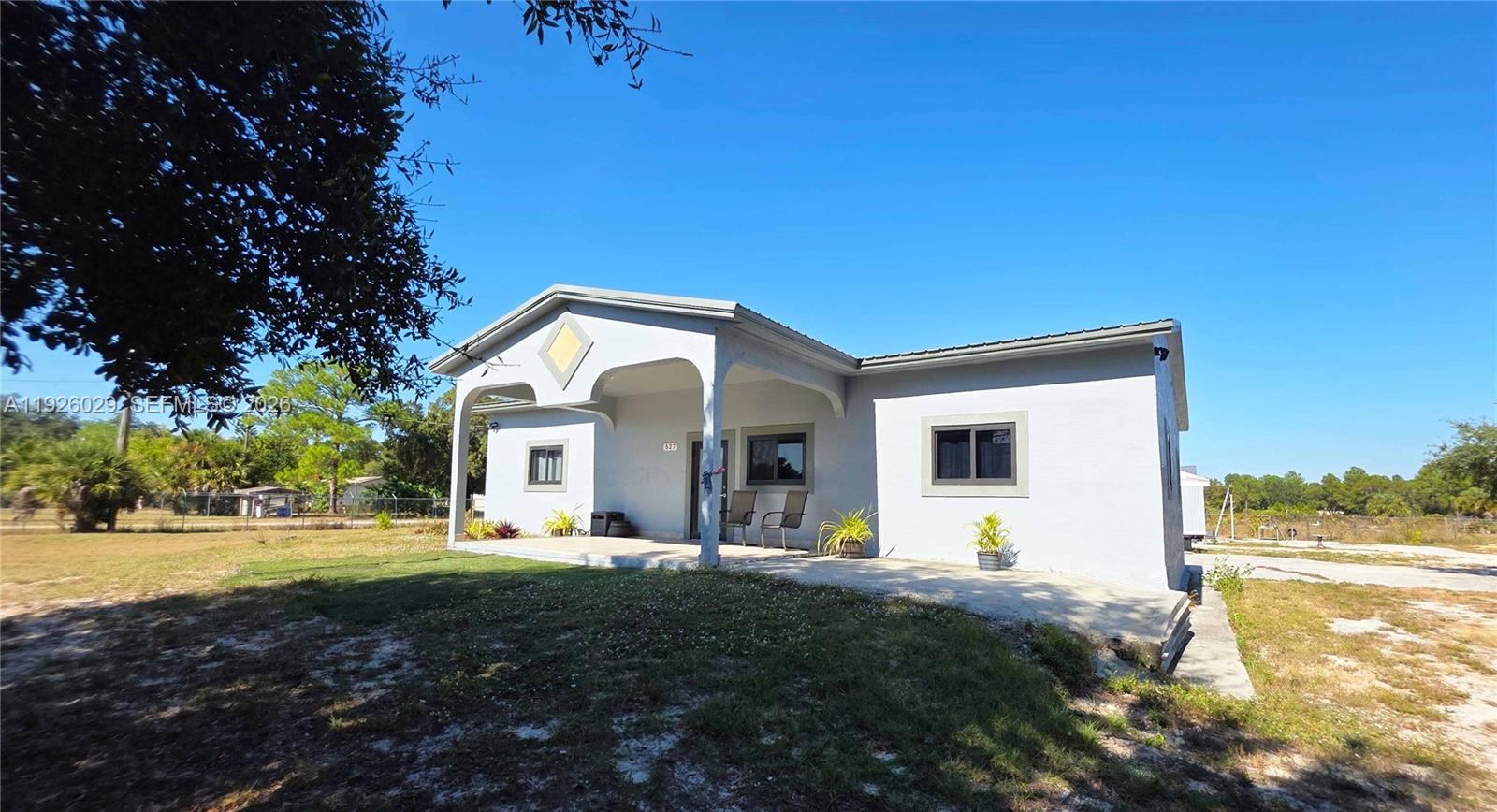 A single-story house with a covered front porch sits on a grassy lot — 527 PERIMETER RD, Clewiston FL 33440, CLEWISTON, FL