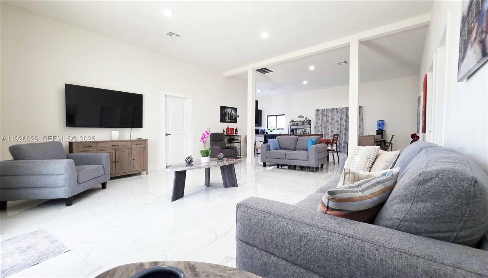 A living room features gray furniture, a marble-topped coffee table, and white tiled floors — 527 PERIMETER RD, Clewiston FL 33440, CLEWISTON, FL