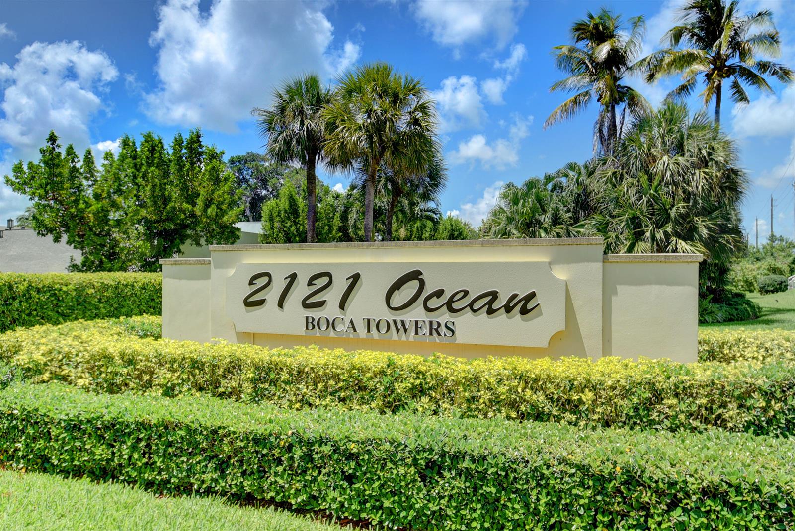A beige monument sign for Boca Towers stands behind a manicured green hedge — 2121 N Ocean Boulevard # 1406w, Boca Raton FL 33431, BOCA RATON, FL