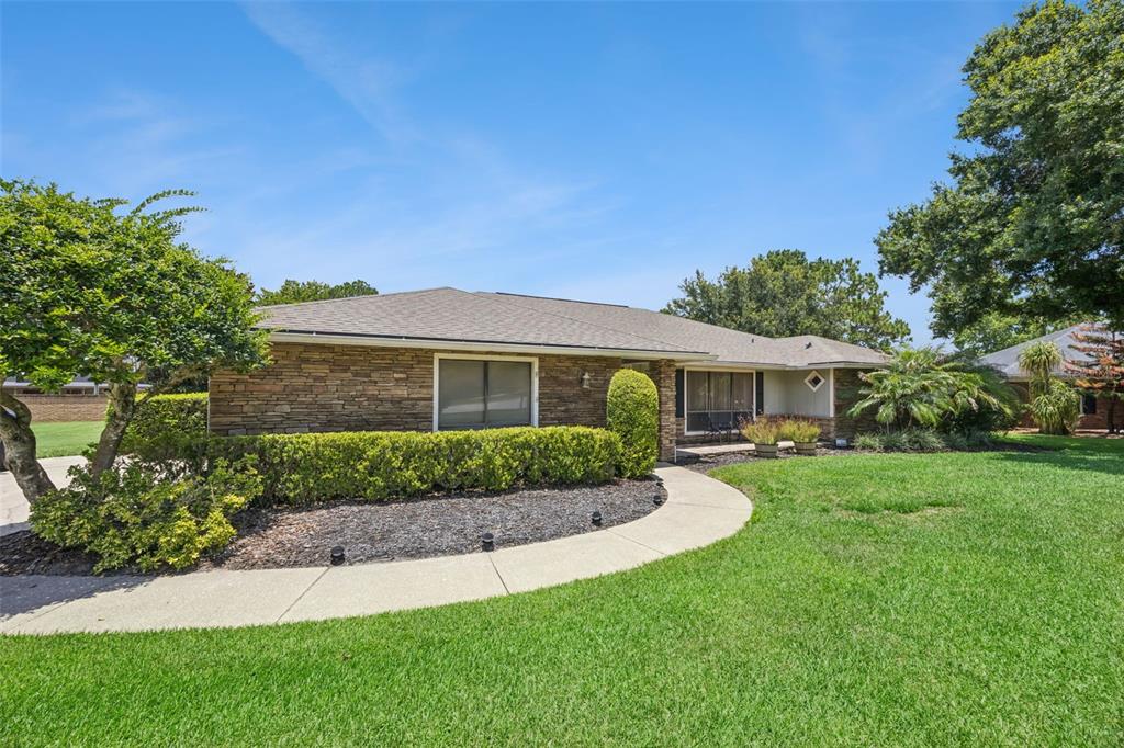 A single-story house with a stone facade, a curved walkway, and a manicured lawn — 783 KEENELAND PIKE, LAKE MARY, FL
