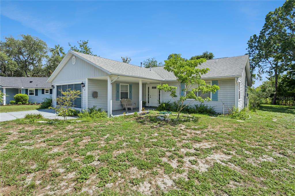 An aerial view shows several houses with driveways surrounded by dense trees and open fields — 32 GORDON COURT, LEESBURG, FL
