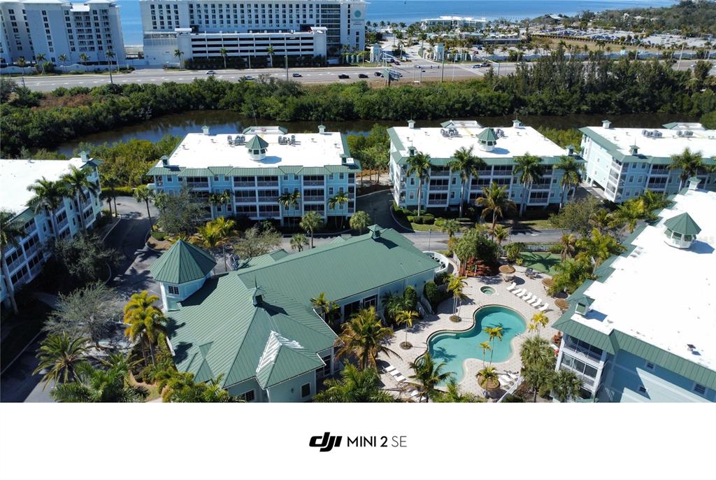 An aerial view shows a resort-style complex with multiple buildings, a swimming pool, and landscaping — 5127 MELBOURNE STREET UNIT F103, PUNTA GORDA, FL