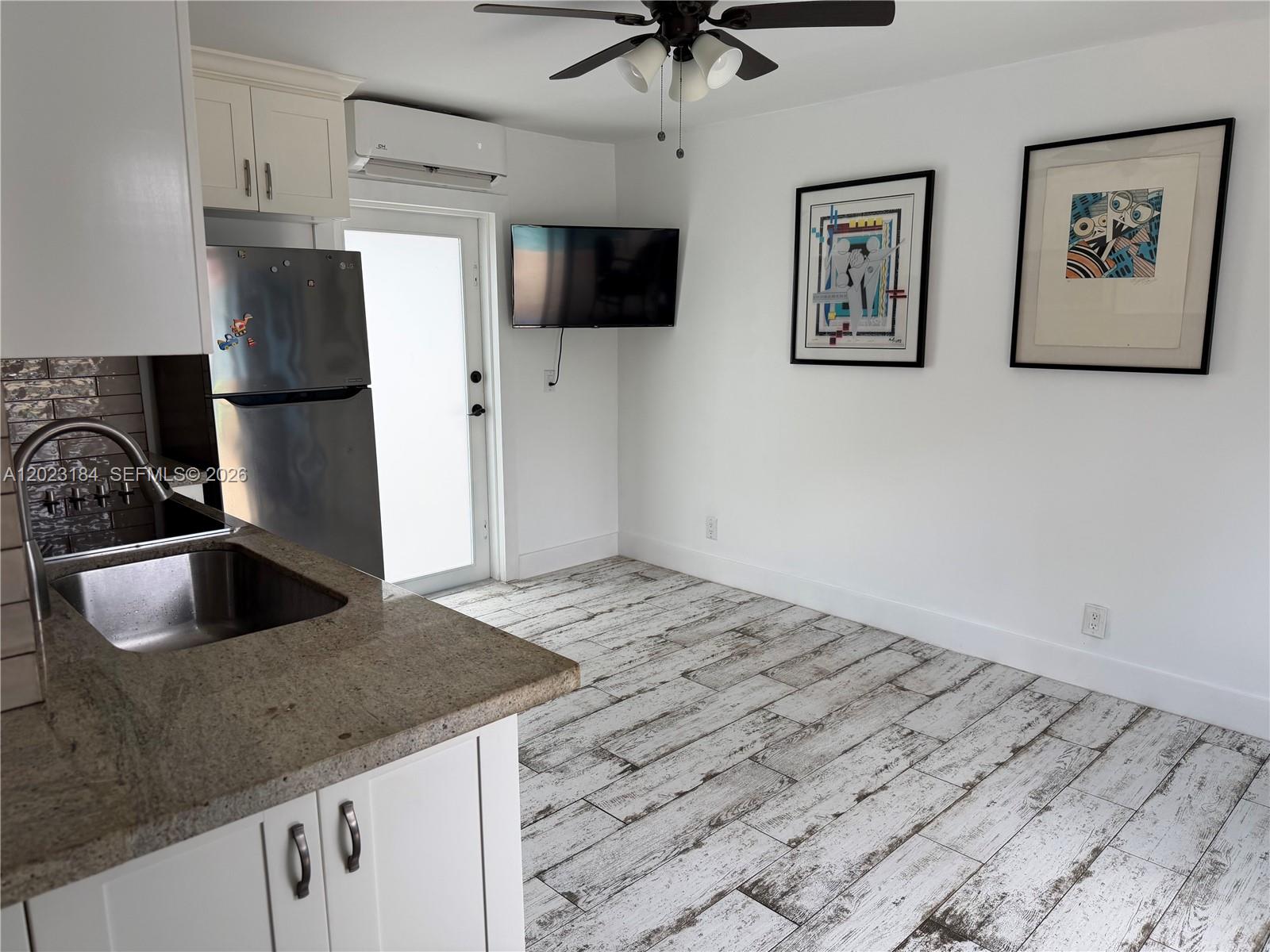 A kitchen with white cabinets, stainless steel appliances, and wood-look tile flooring — 3837 NE 17th Ave, Pompano Beach FL 33064, POMPANO BEACH, FL