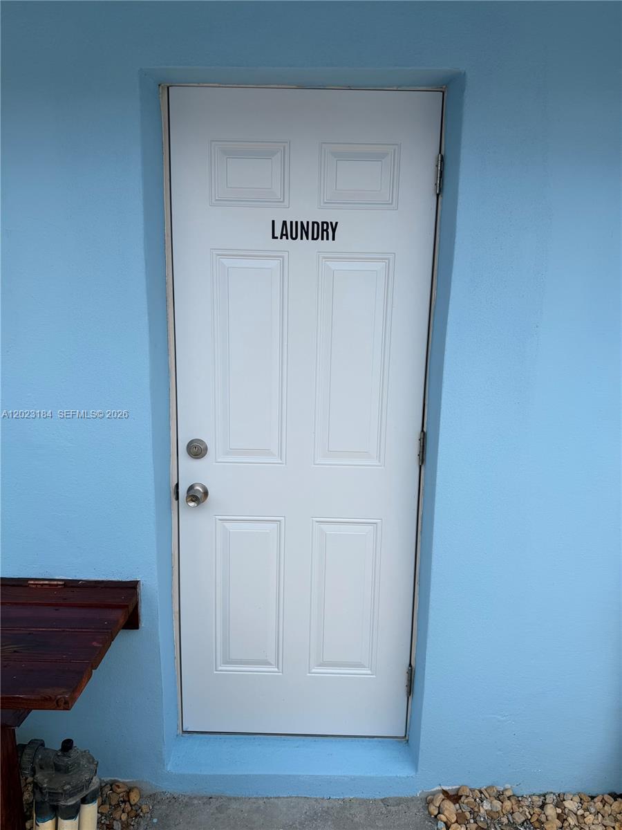 A white door labeled laundry is set into a light blue exterior wall — 3837 NE 17th Ave, Pompano Beach FL 33064, POMPANO BEACH, FL