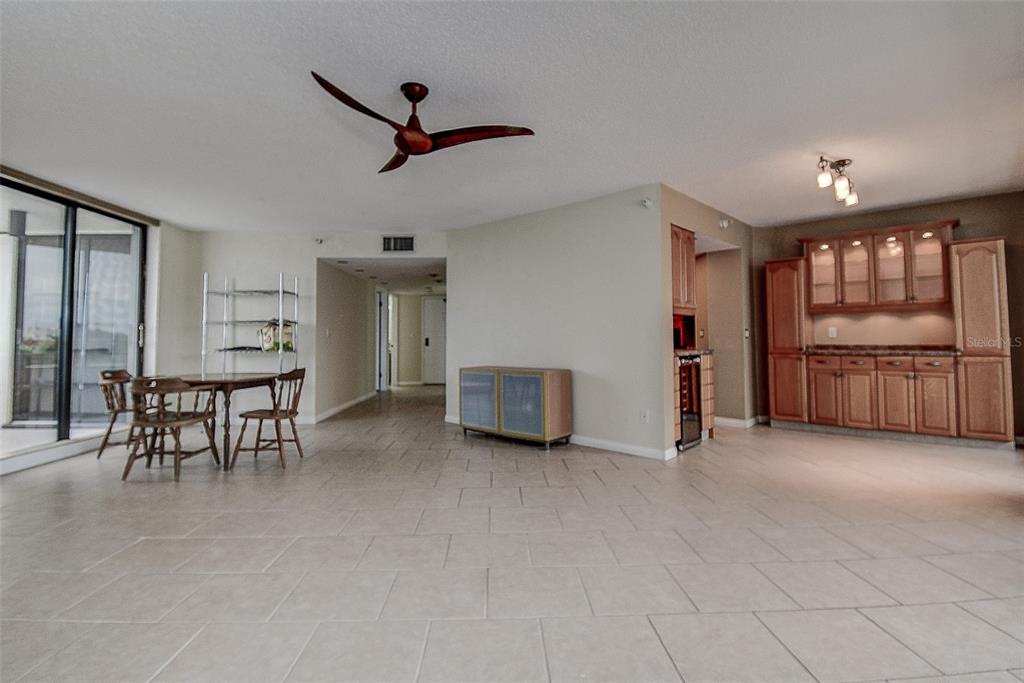 An open-concept dining and kitchen area features tile flooring, wood cabinetry, and a ceiling fan — 5940 PELICAN BAY PLAZA S UNIT 406, GULFPORT, FL