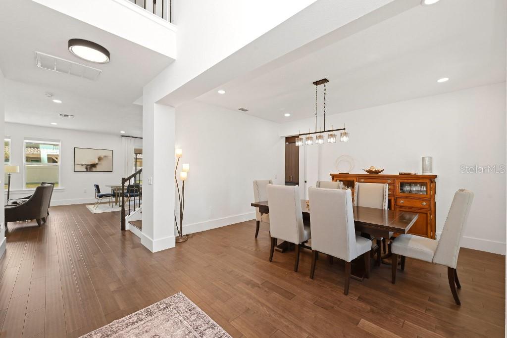 A dining room with a wooden table, upholstered chairs, and a wooden sideboard — 8426 MOREHOUSE DRIVE, ORLANDO, FL