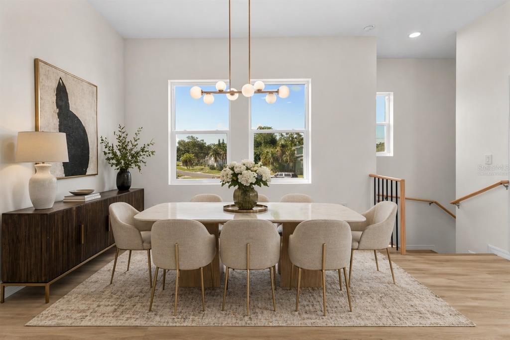 A dining room features a marble table, eight upholstered chairs, and a modern globe chandelier — 4234 4TH STREET S, ST PETERSBURG, FL