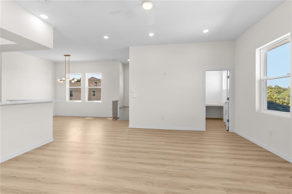 A bright, open-concept living area features light wood-look flooring, recessed lighting, and a small office — 4234 4TH STREET S, ST PETERSBURG, FL