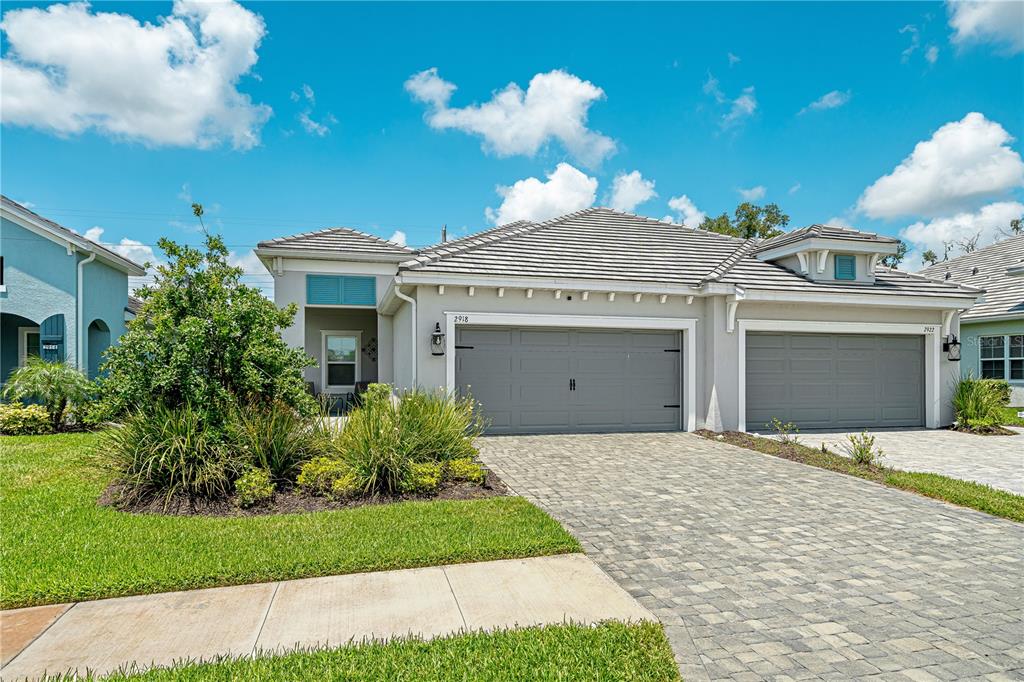 A single-story house with a gray garage, tiled roof, and a paved driveway — 2918 BUTTERFLY JASMINE TRAIL, SARASOTA, FL