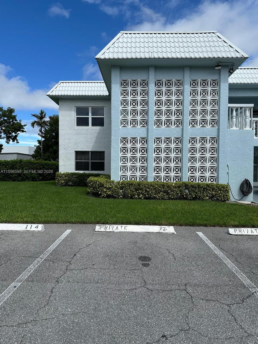 A light blue two-story building features decorative concrete screen blocks and designated parking spaces — 9848 Marina Blvd # 811, Boca Raton FL 33428, BOCA RATON, FL
