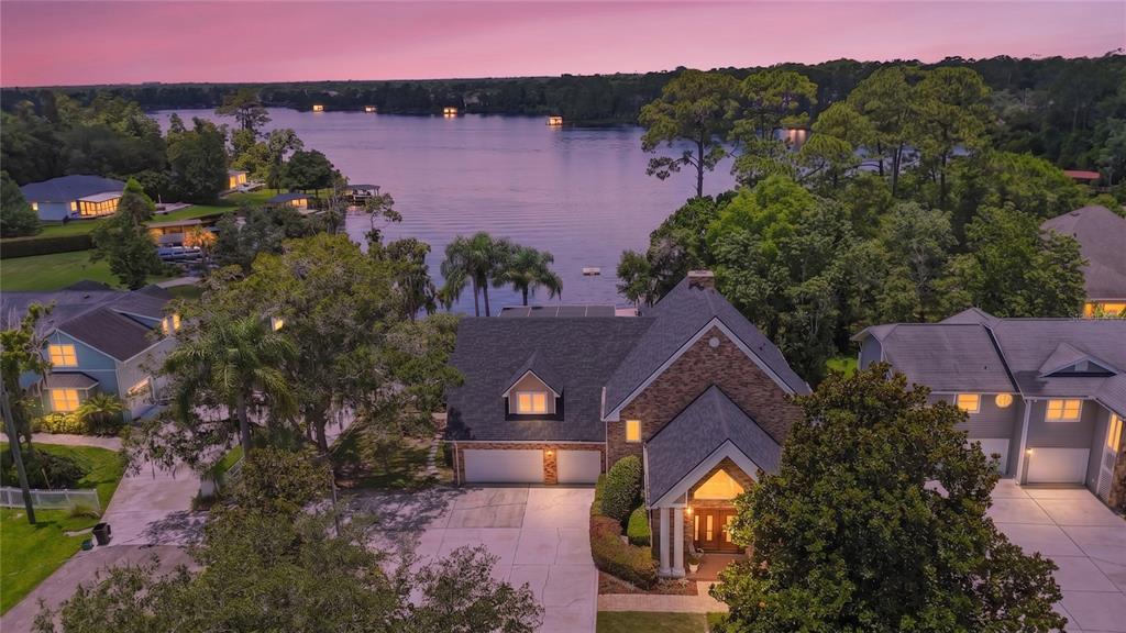 An aerial view of a brick house with a two-car garage overlooking a large lake — 240 W 7TH STREET, CHULUOTA, FL