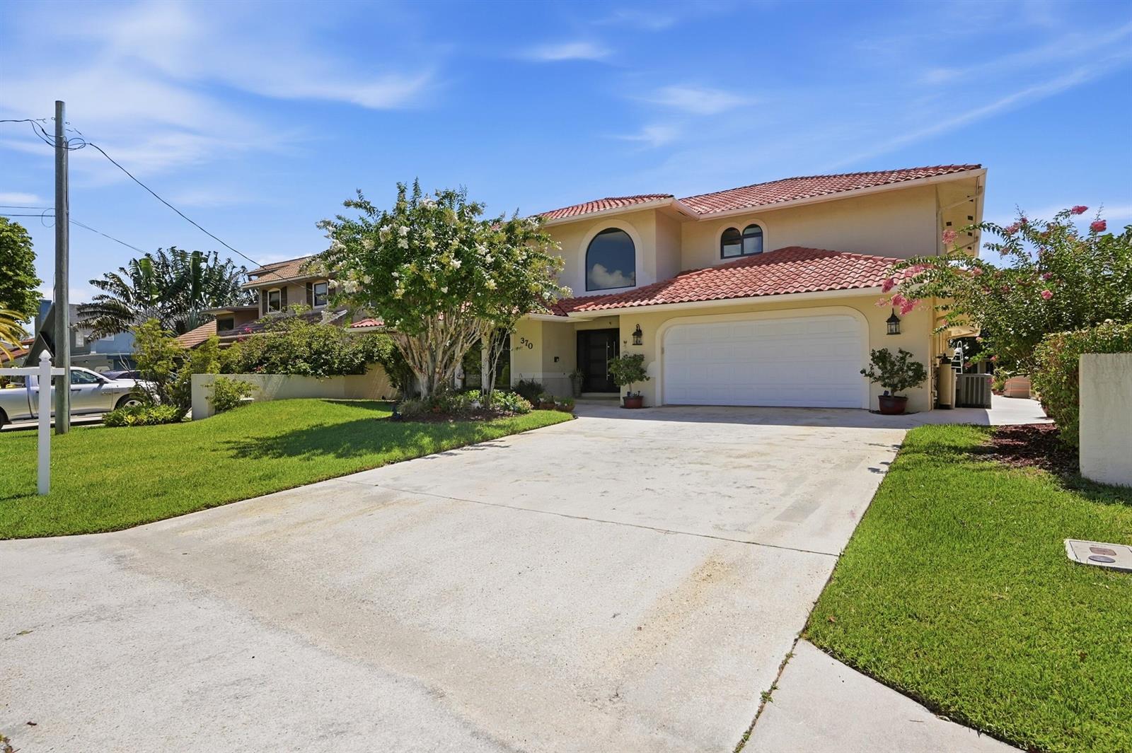 A two-story house with a red tile roof, white garage, and a concrete driveway — 370 SE 13th Avenue, Pompano Beach FL 33060, POMPANO BEACH, FL
