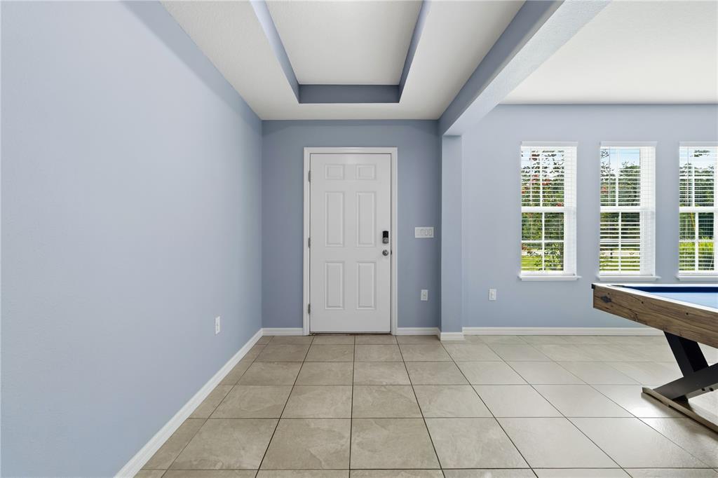 A tiled entryway features light blue walls, a white front door, and a recessed ceiling — 14557 CEDARWOOD AVENUE, WEEKI WACHEE, FL