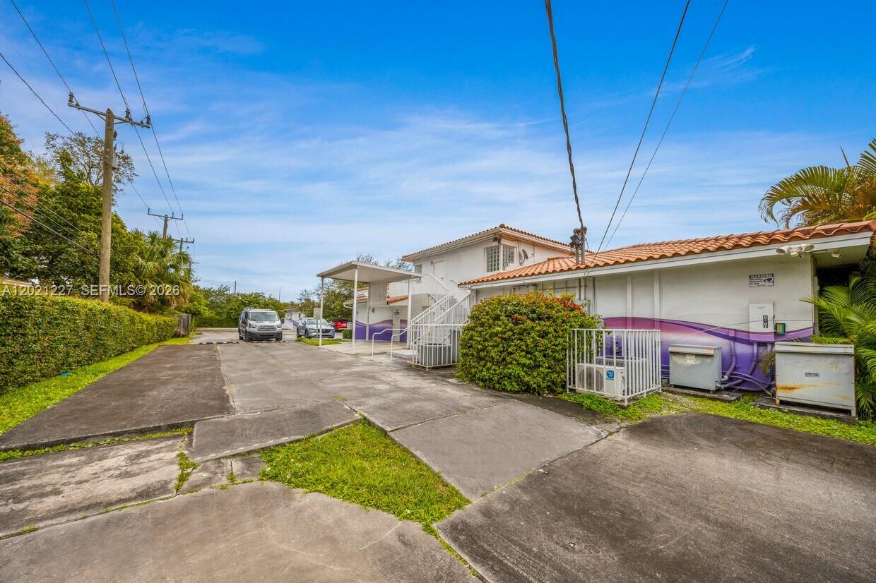 A low-rise building with a purple-painted exterior and a concrete parking area — 49 W 49TH St, Miami Beach FL 33012, MIAMI BEACH, FL