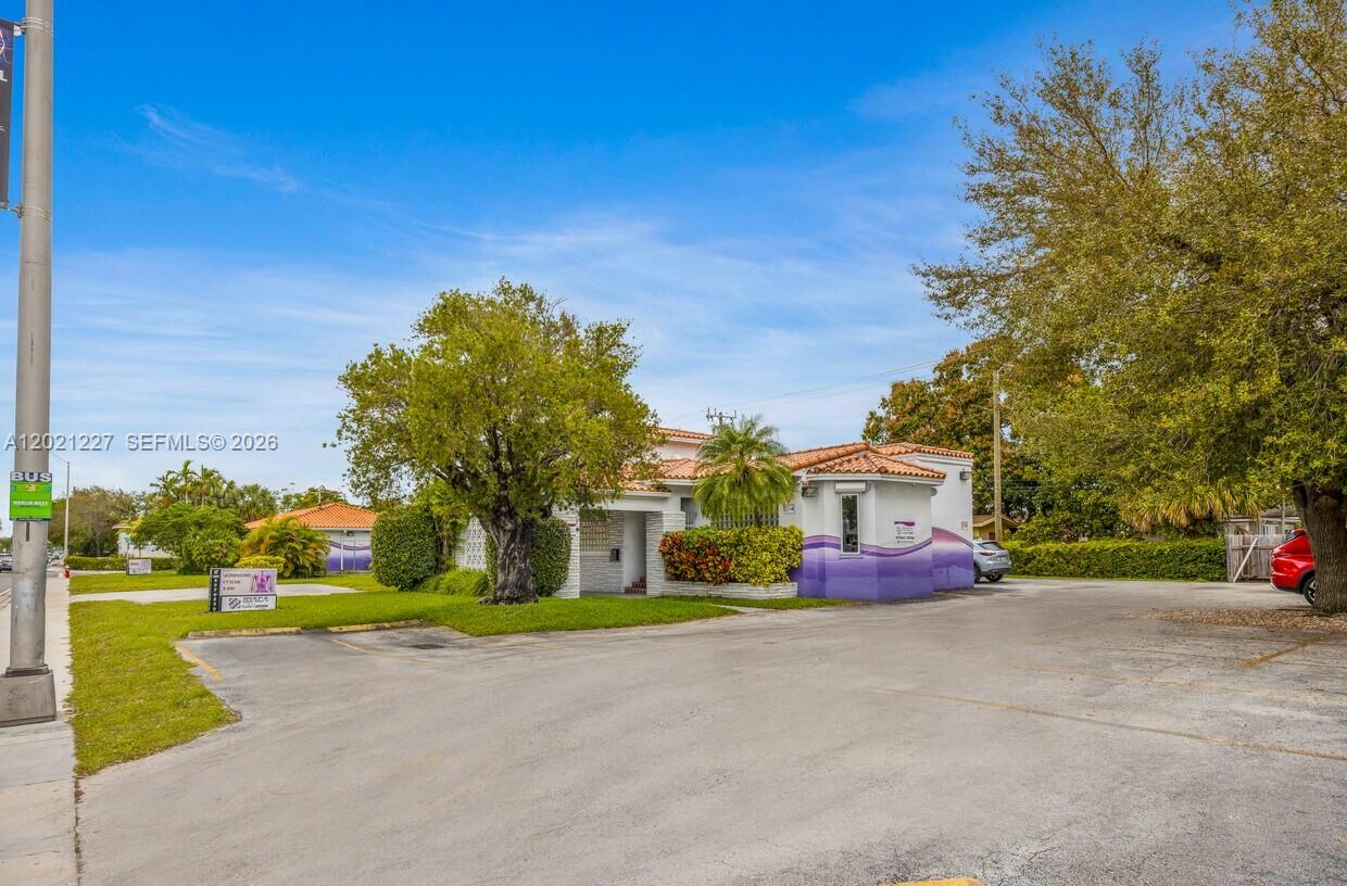 A low-rise building with a purple-painted base sits behind a paved parking lot — 49 W 49TH St, Miami Beach FL 33012, MIAMI BEACH, FL