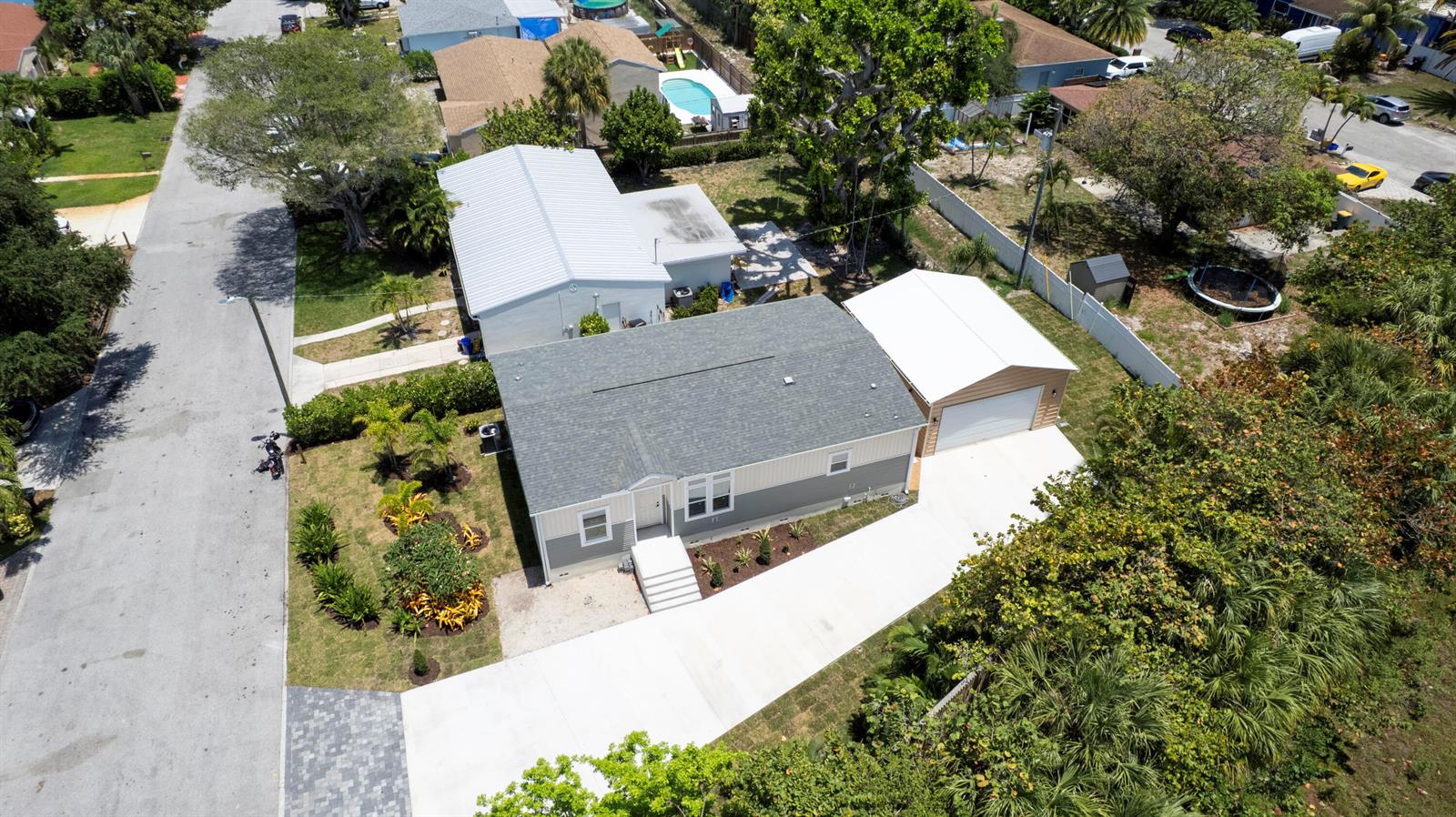 An aerial view shows a single-story house with a gray roof and attached white garage — 1757 N 12th Ct Court N, FL 33460, FL