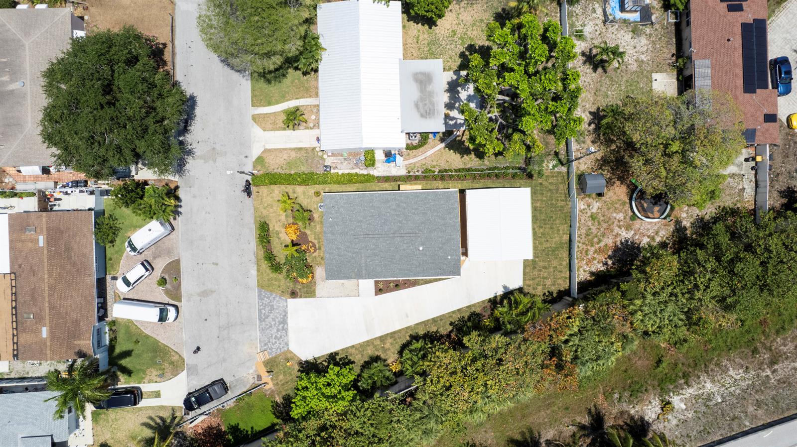 An aerial view shows a residential house with a gray roof, driveway, and surrounding landscaping — 1757 N 12th Ct Court N, FL 33460, FL