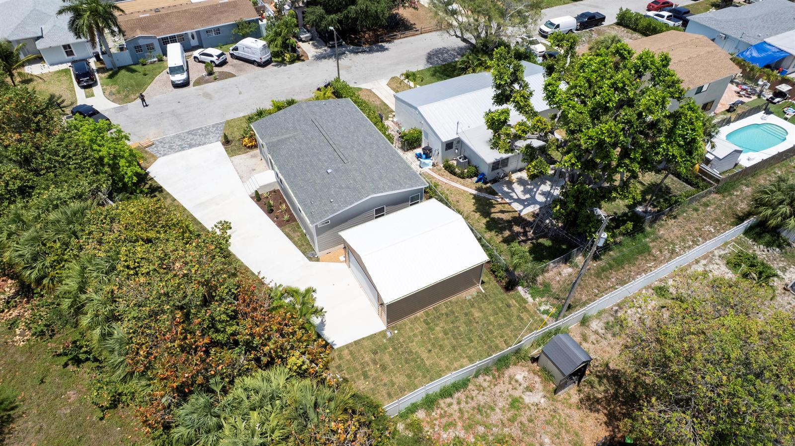 An aerial view shows a house with a detached garage, driveway, and fenced backyard — 1757 N 12th Ct Court N, FL 33460, FL