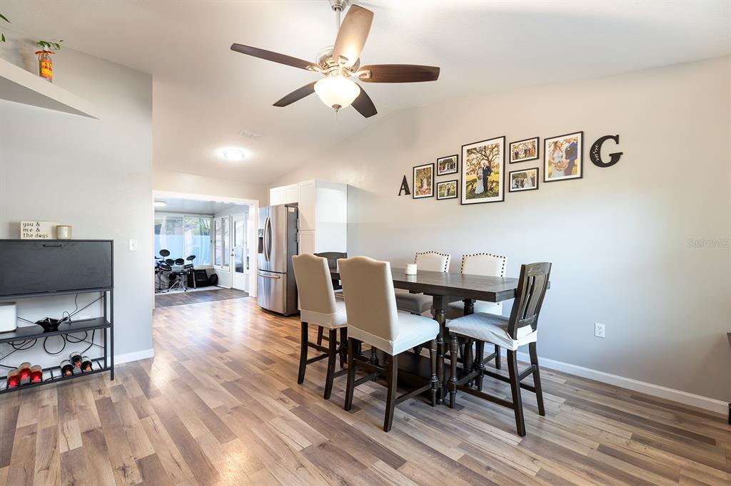 A dining room features a wooden table, upholstered chairs, a bench, and a ceiling fan — 12146 VIRGINIA DRIVE, LEESBURG, FL
