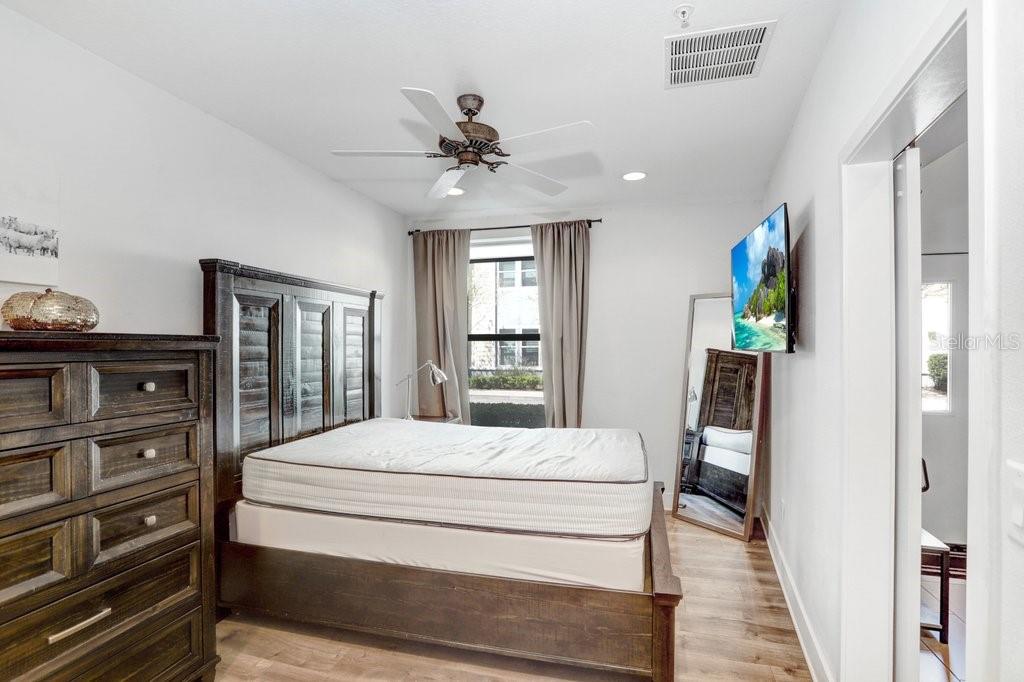 A bedroom features a wooden bed frame, a tall dresser, and a wall-mounted television — 2511 N GRADY AVENUE UNIT 85, TAMPA, FL