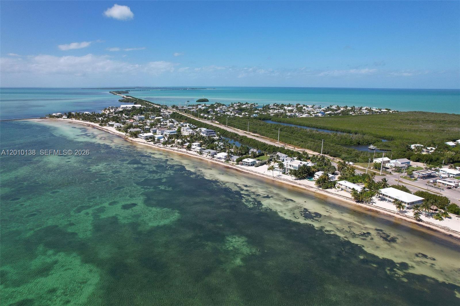 An aerial view shows a coastal neighborhood with houses along a beach and highway — 74049 Overseas, Islamorada FL 33036, ISLAMORADA, FL