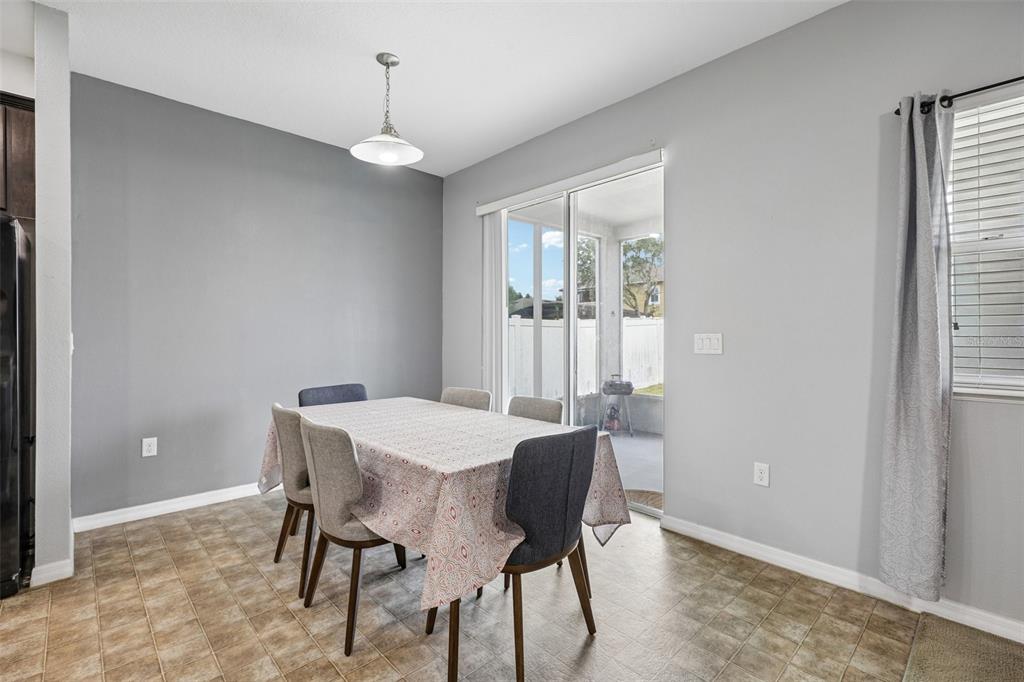 A dining room with a table, chairs, tile flooring, and a sliding glass door — 954 REVERE AVENUE, HAINES CITY, FL
