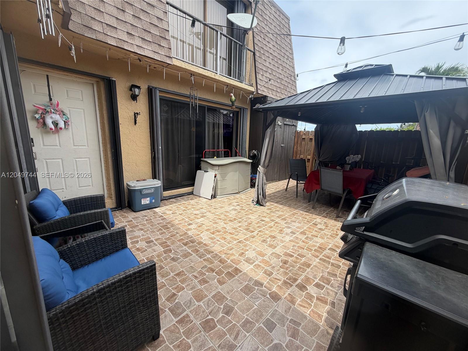 A paved patio features a gazebo with a dining set, a grill, and outdoor seating — 4804 Waterview Cir, Palm Springs FL 33461, PALM SPRINGS, FL