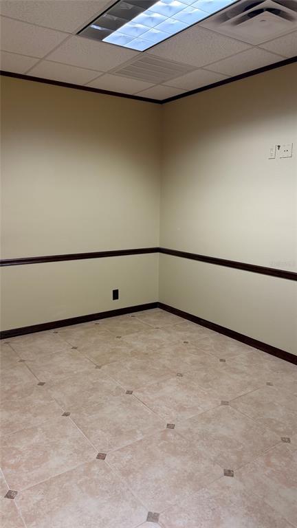 An empty office room features beige walls, dark chair rail molding, and light-colored tile flooring — 411 APOLLO BEACH BOULEVARD UNIT 800, APOLLO BEACH, FL