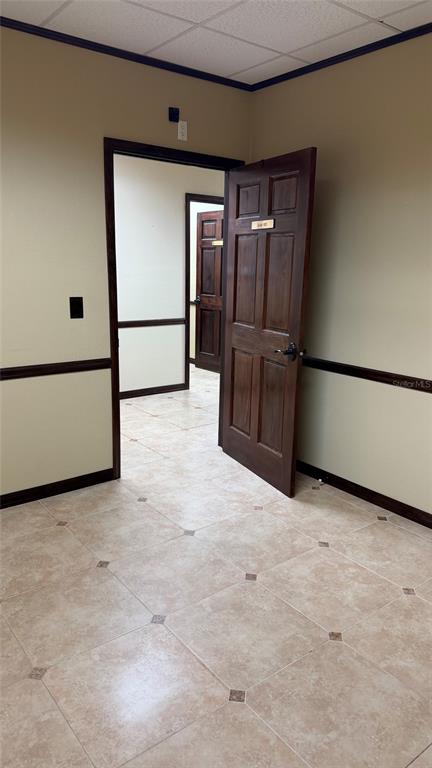 An interior view shows a tiled room with a wooden door leading to another office — 411 APOLLO BEACH BOULEVARD UNIT 800, APOLLO BEACH, FL