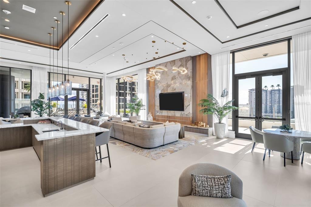 A modern open-concept living room features a kitchen island, large sofa, and floor-to-ceiling windows — 275 1ST AVENUE S UNIT 2807, ST PETERSBURG, FL