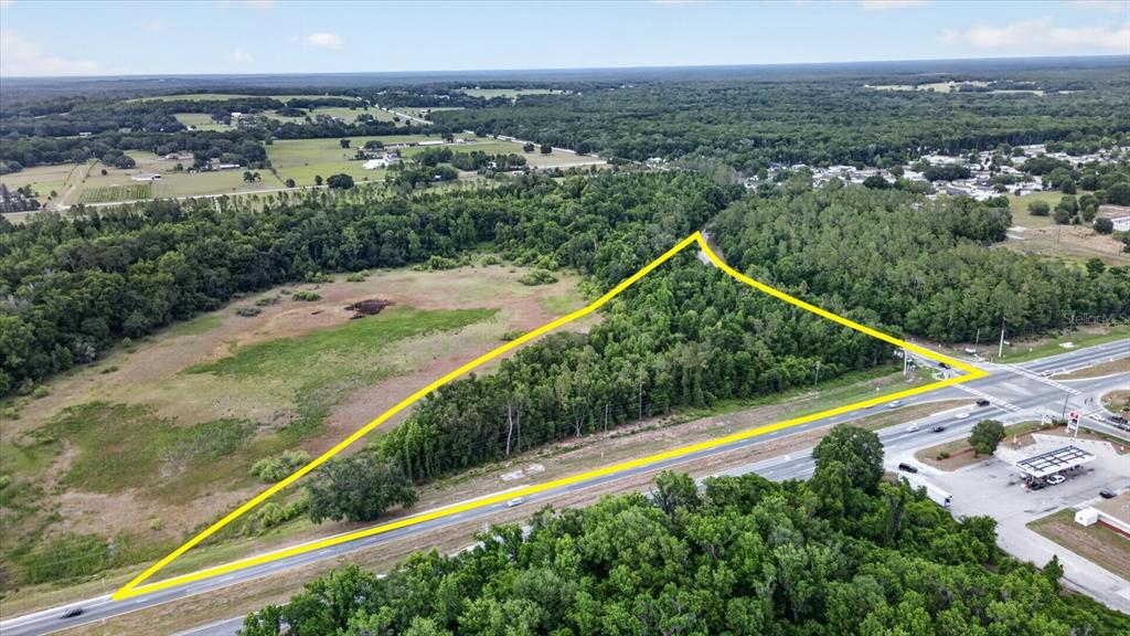 An aerial view shows a triangular plot of land bordered by roads and trees — MONDON HILL, BROOKSVILLE, FL