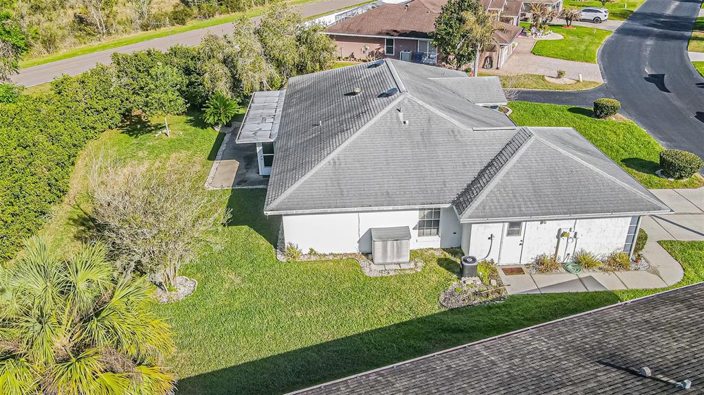 An aerial view of a single-story house with a gray shingled roof and white walls — 10504 MOSHIE LANE, SAN ANTONIO, FL