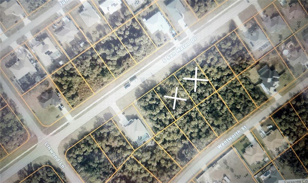 This is an aerial map showing two adjacent vacant lots marked with white X symbols — S SAN MATEO DRIVE, NORTH PORT, FL