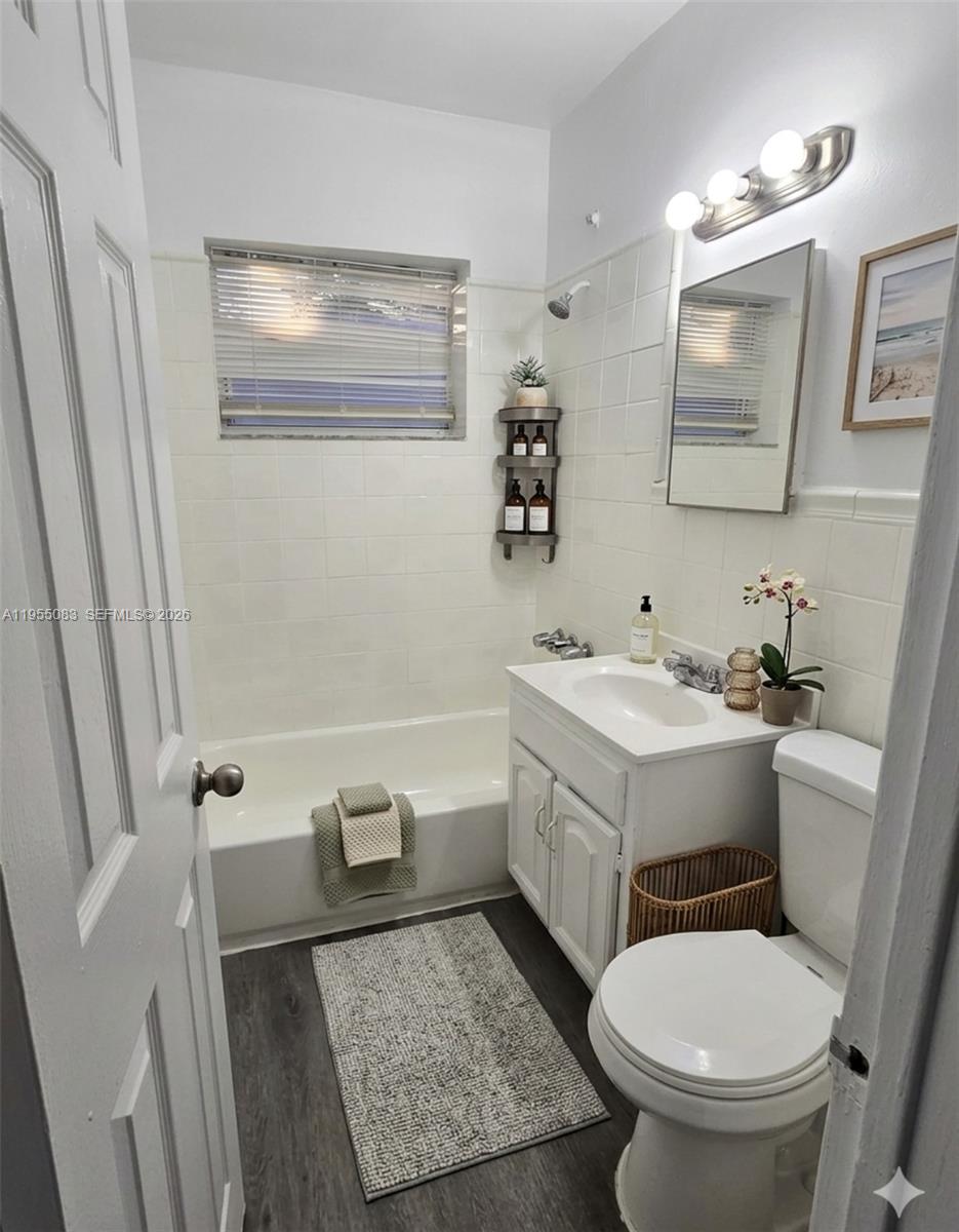 A small, empty room features gray wood-look flooring, white walls, and a black track light — 2729 NW 47th St, Miami FL 33142, MIAMI, FL