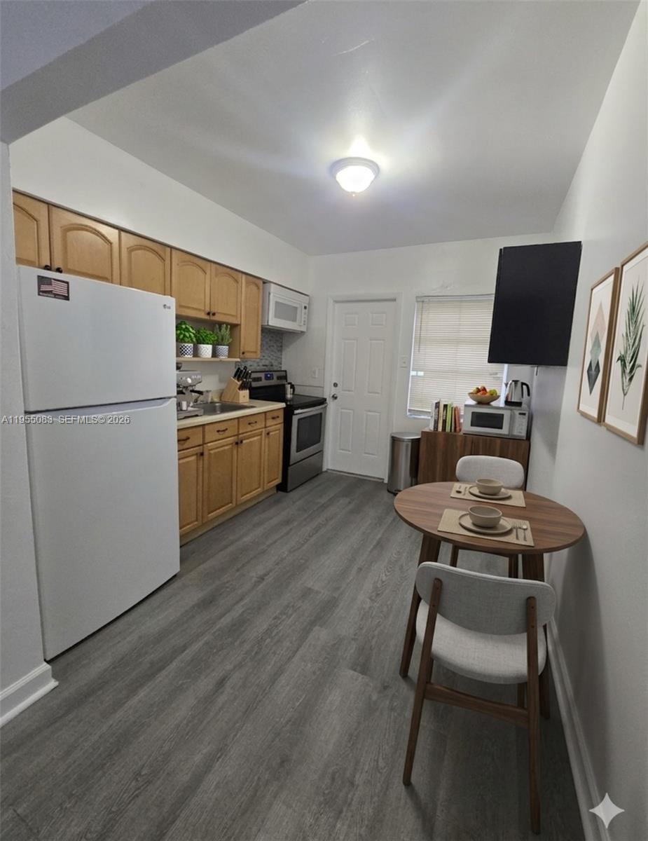 An empty bedroom features white walls, a ceiling light, two windows, and gray wood-look flooring — 2729 NW 47th St, Miami FL 33142, MIAMI, FL