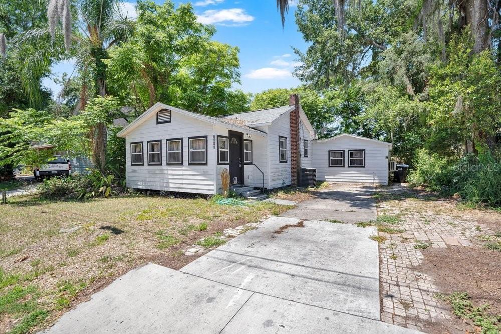 A white single-story house with a front-facing gable and a white picket fence — 2804 KEYSTONE DRIVE, ORLANDO, FL