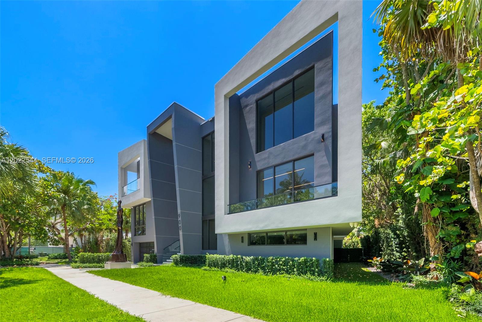 A modern multi-story home features a gray facade with large glass windows and balconies — 900 NE 75th St, Miami FL 33138, MIAMI, FL
