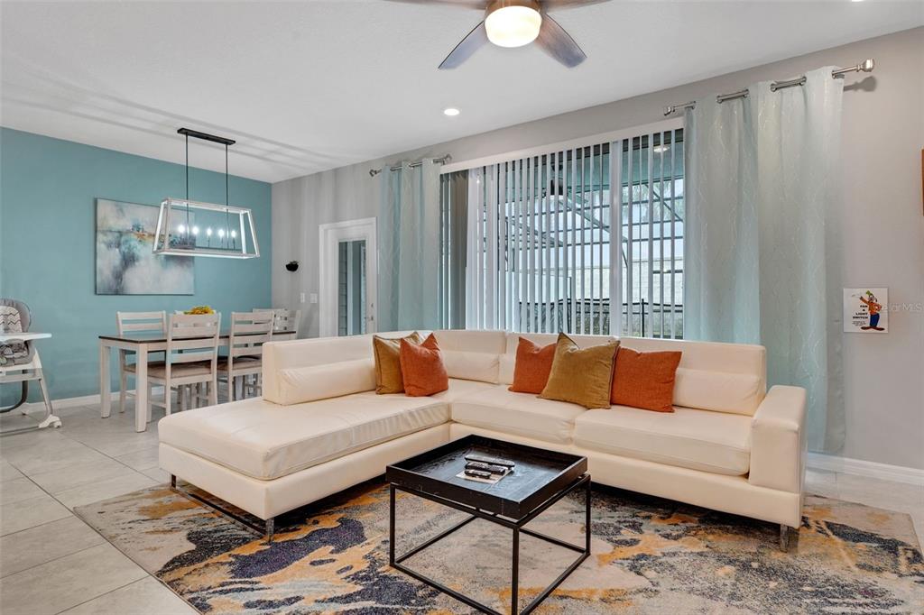 A living room with a white sectional sofa, a coffee table, and an adjacent dining area — 720 GARDENIA LANE, DAVENPORT, FL