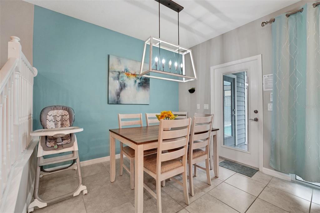 A dining area features a wooden table, four chairs, a high chair, and a blue wall — 720 GARDENIA LANE, DAVENPORT, FL