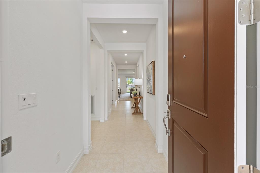 A view from an open brown front door looking down a tiled hallway — 3335 NW 52ND AVENUE ROAD, OCALA, FL