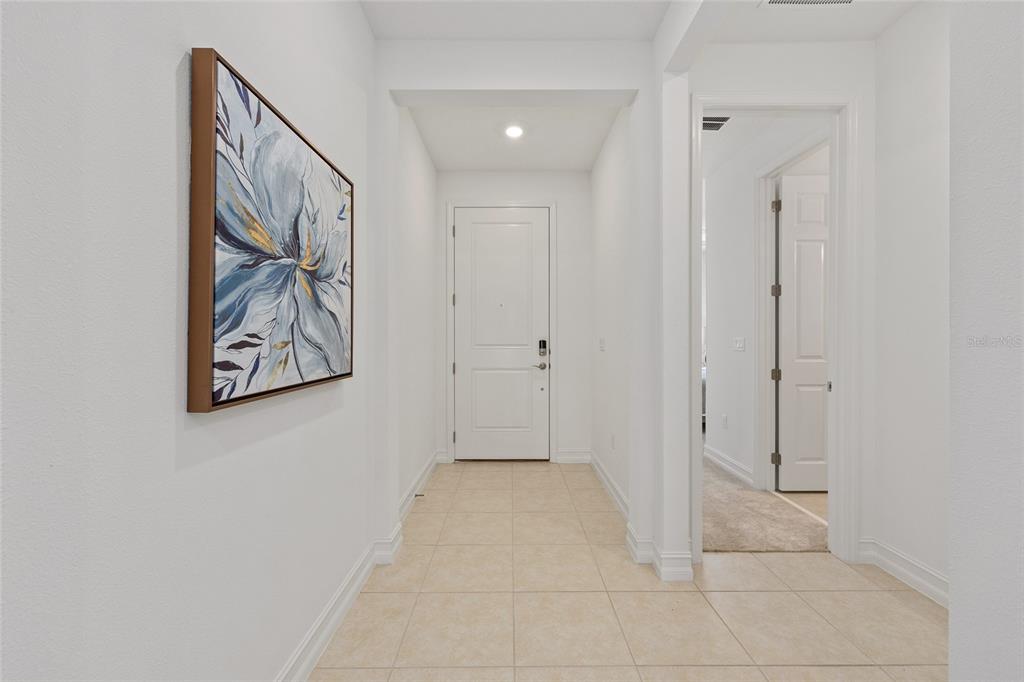 A tiled entryway features a white front door, a framed floral painting, and a doorway — 3335 NW 52ND AVENUE ROAD, OCALA, FL