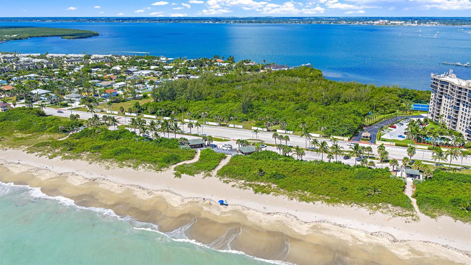 An aerial view shows a sandy beach, a coastal road, dense vegetation, and a high-rise building — 901 S Ocean Drive, Fort Pierce FL 34949, FORT PIERCE, FL